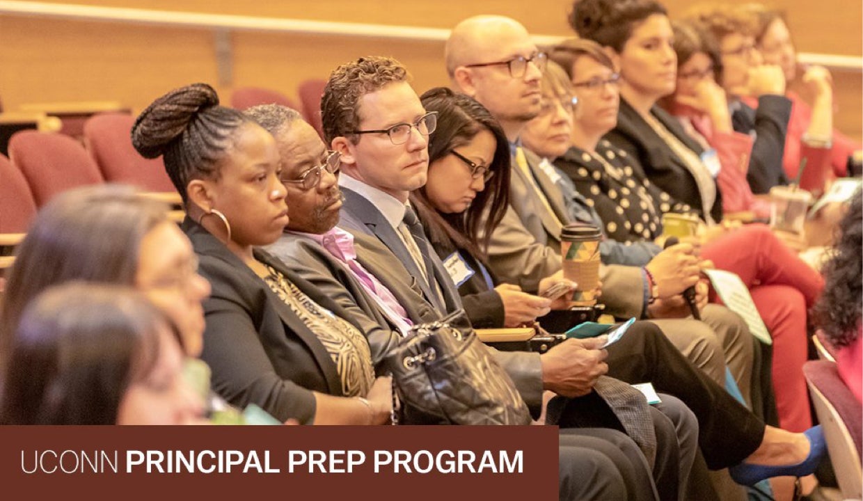 Education leaders sit in the audience at a conference.